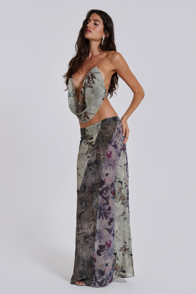 Female model wearing a floral maxi length skirt with panelled patchwork detail. Styled with the matching cowl neck top. 