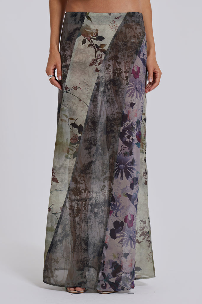 Female model wearing a floral maxi length skirt with panelled patchwork detail. Styled with the matching cowl neck top. 