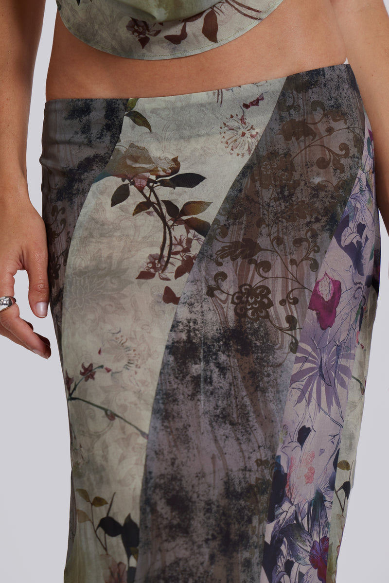 Female model wearing a floral maxi length skirt with panelled patchwork detail. Styled with the matching cowl neck top. 